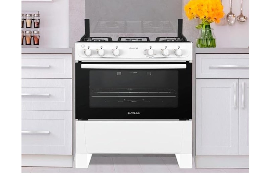 Fogão 5 Bocas Atlas Mônaco Plus Branco com mesa de inox e forno fechado em cozinha iluminada.