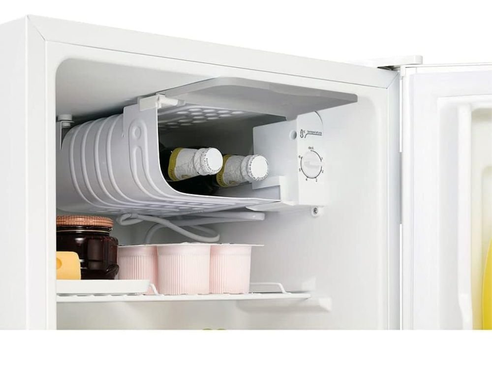 "Frigobar Midea 45L Branco 127V em ambiente decorado, com a porta entreaberta mostrando prateleiras organizadas com bebidas, destacando o design compacto e o selo de eficiência energética Procel A.